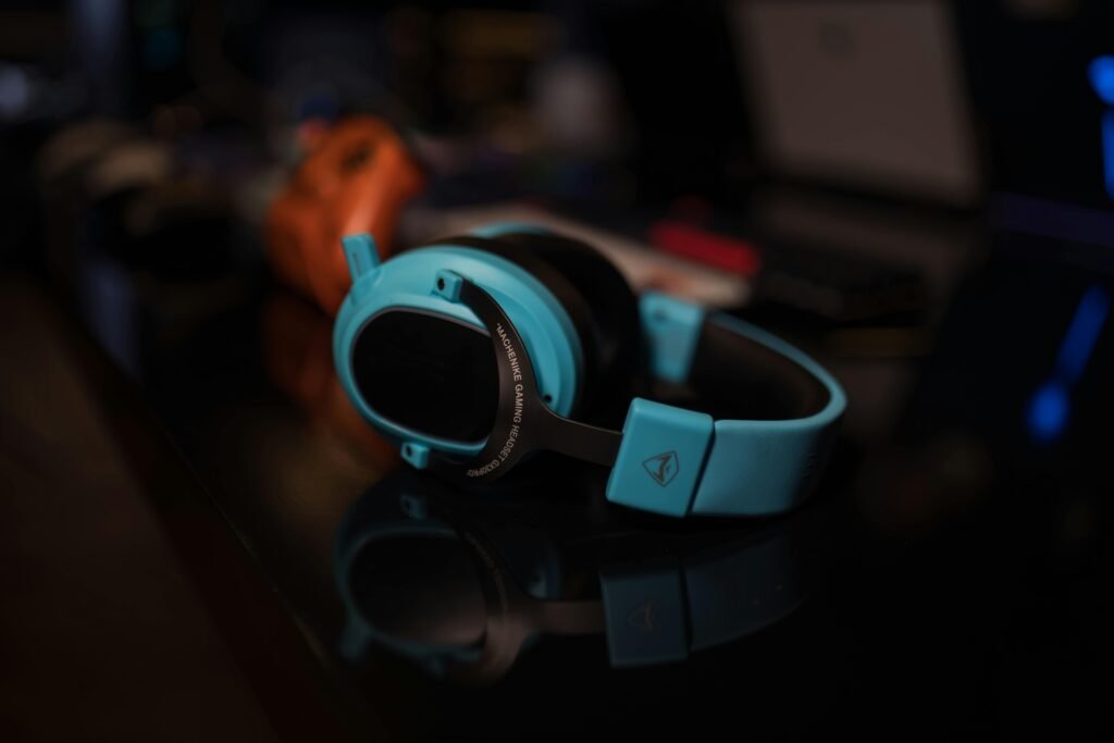 Headset gamer Machenike azul claro sobre mesa com superfície reflexiva.