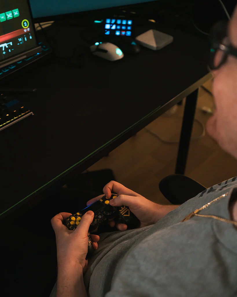 Close-up do pro player Huke, da OpTic Gaming, jogando com controle personalizado preto e amarelo em setup de Call of Duty.
