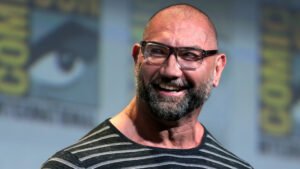 Dave Bautista sorrindo no painel do San Diego Comic-Con 2016, ator confirmado como o novo Kratos na serie de God of War